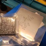 PCB del progetto ProvaTelecomando IR appena ricevuto, ancora nella confezione, affiancato dallo stencil metallico per la deposizione della pasta saldante.