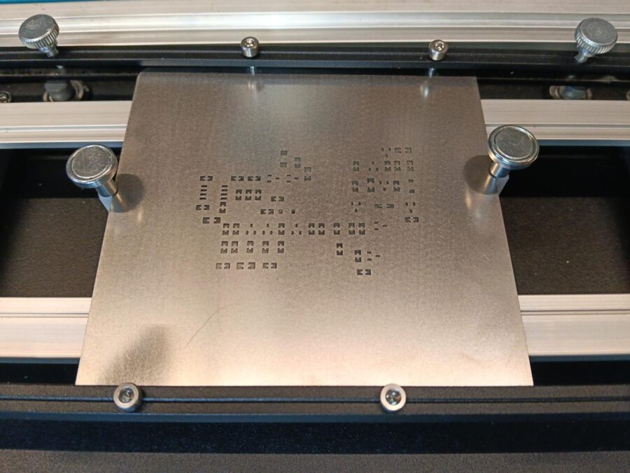 Stencil della PCB GX-TXT-v3 disposto sulla stampante manuale prima della deposizione della pasta saldante.